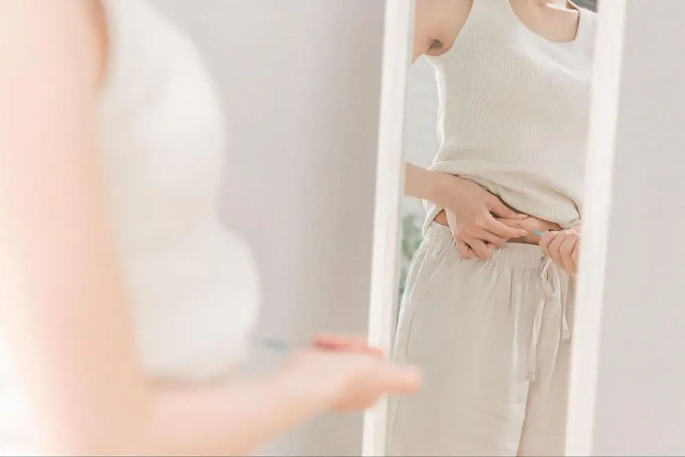 ウエストをつまむ女性
